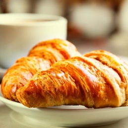 breakfast with croissants, cup of black coffee and newspaper